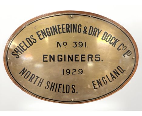 A Shields Engineering & Dry Dock Co Ld North Shields brass oval plaque, dated 1929, mounted on wooden panel, 42cm by 30cm. 