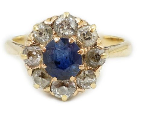 An 18ct gold, sapphire and diamond cluster ring, the central round cut sapphire bordered by old round cut diamonds, size M, g