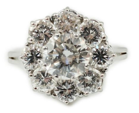 A modern 18ct white gold and round brilliant cut nine stone diamond set cluster ring, the centre stone weighing approximately