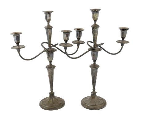 A pair of George V silver two branch, three light candelabra, by Eugene Leclere, with engraved inscription and tapering octag