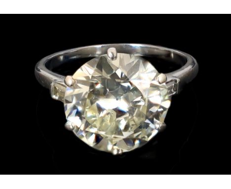 A platinum and single stone diamond set ring, with baguette cut diamond set shoulders, the round cut stone weighing approxima