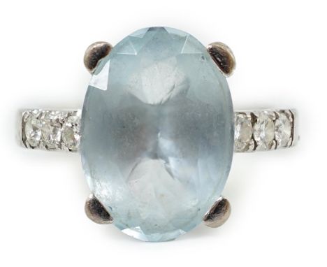 A modern 18ct white gold and single stone oval cut aquamarine set ring, with six stone diamond set shoulders, size O, gross w