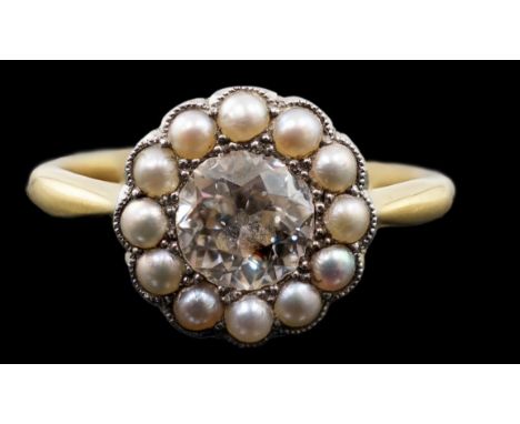 An early 20th century 18ct gold, diamond and millegrain set seed pearl circular cluster ring, the round cut stone weighing ap