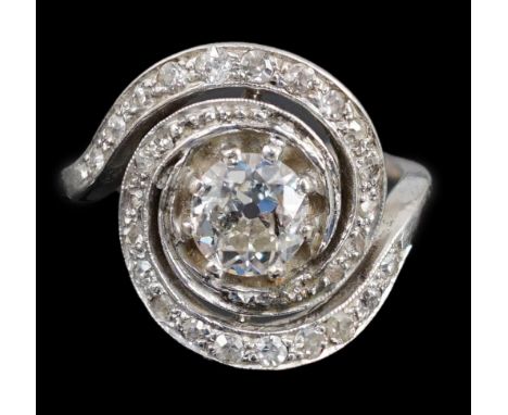 A mid 20th century platinum and diamond cluster set ring, of spiralling design, the central stone measuring approximately 6.6