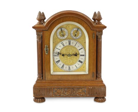 An Edwardian golden oak eight day bracket clock in arched architectural case with fluted side columns, the arched dial with s