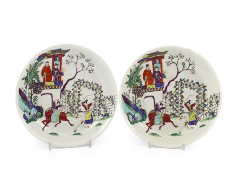 A pair of Chinese famille rose saucer dishes, Yongzheng mark but first half 19th century, each painted with ladies performing