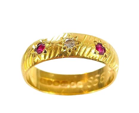 A 1960's 22ct hallmarked gold diamond and ruby set three stone band ring. The diamond measure 0.03ct, the two rubies of simil