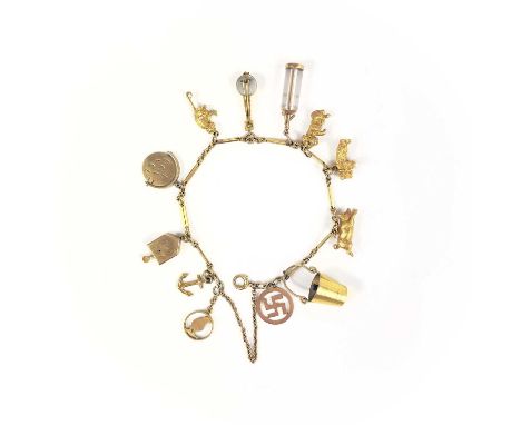 A 9ct gold charm bracelet. With 11 9ct and gold charms, including a begging dog with ruby eyes and a bear holding a pearl, 22