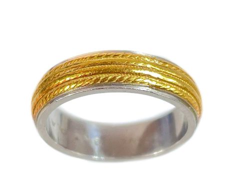 An 18ct and platinum band ring. The middle gold band with engraved decoration, stamped 18KT PLAT, size J, 6.47g.