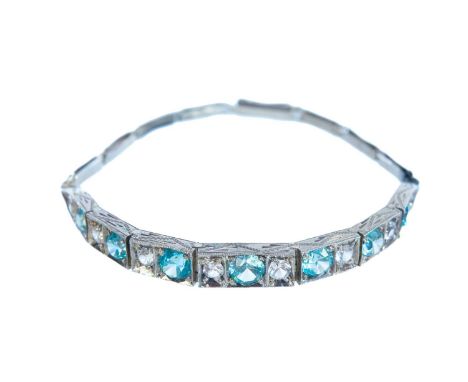 An attractive 1920's Art Deco platinum blue zircon and silica glass set bracelet. The seven hinged panel centrepiece is mille