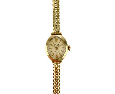 A 1960's 9ct gold ladies manual wind bracelet wristwatch. The 13mm oval cream dial signed MAJEX, 21 jewel movement, in Benson