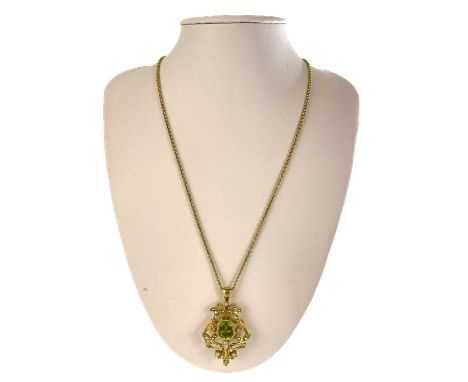 An Art Nouveau high purity gold (tests 14ct) peridot and seed pearl set brooch pendant. The emerald cut peridot measures 4ct 