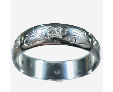 A modern 18ct white gold diamond set band ring. Foliate scroll bright cut set with six small diamonds, Birmingham 1981, size 