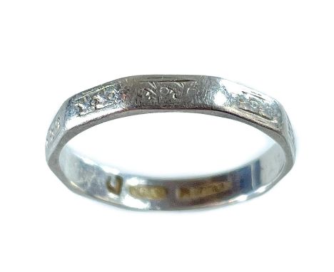 A platinum band ring. Facetted with engraved decoration, size K 1/2, 2.6g.