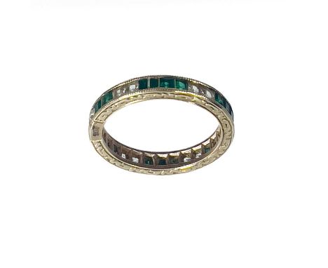 A 9ct gold white and green stone set full eternity ring. The square cut stone channel set, size K 1/2, 2g (one stone missing)