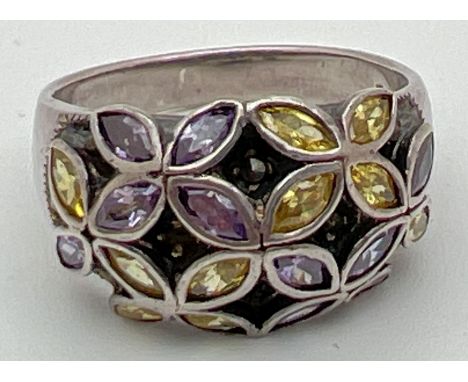 A modern design dome style silver dress ring with stone set flower detail. Ring set with purple and yellow marquise cut stone