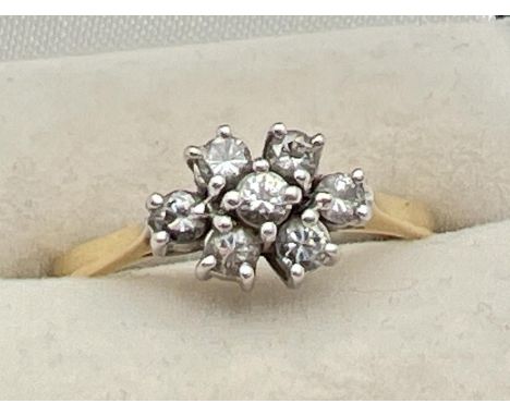 An 18ct gold and diamond ring. with 7 round cut diamonds in a flower shaped setting, totalling .35ct. Fully hallmarked and wi