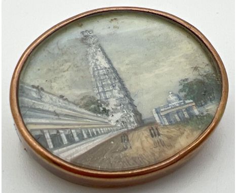 An antique miniature oil painting in a 9ct gold oval brooch. Painting depicts soldiers walking within Army barracks. No gold 