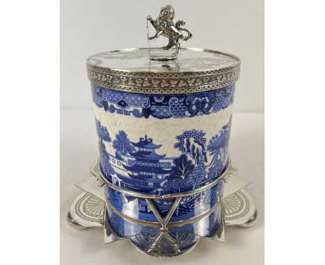 A Victorian ceramic lidded biscuit barrel in a decorative silver plated stand. Barrel with printed blue &amp; white Willow pa