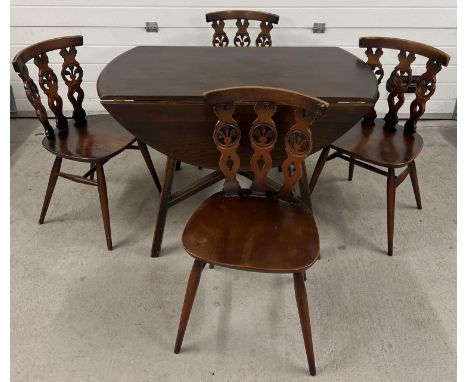 A Mid century Ercol drop leaf dining table together with a set of 4 Ercol dining chairs. Unmarked oval shaped table with cros