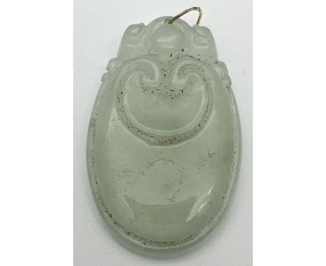 A carved icy jade pendant with a gold coloured metal looped bale. Pendant approx. 5.5cm x 3.5cm. 