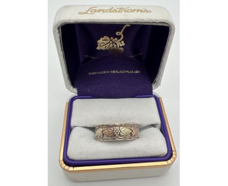 A boxed Landstrom Black Hills sterling silver and 12K rose &amp; yellow gold band ring with floral and leaf design. Silver an