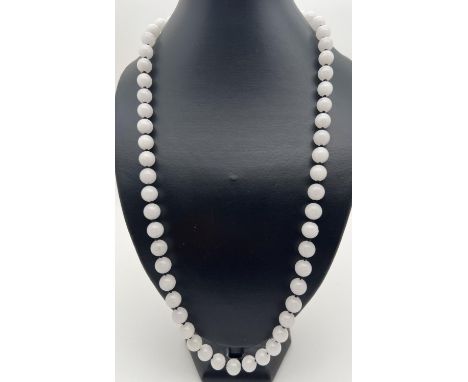A 28" string of white jade beads, knotted between each bead. Beads approx. 1cm diameter. 