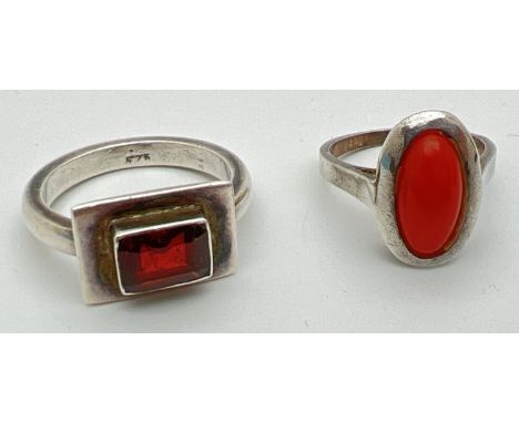 2 silver dress rings. A modern design set with a singular rectangular cut garnet and a vintage silver ring set with an oval c