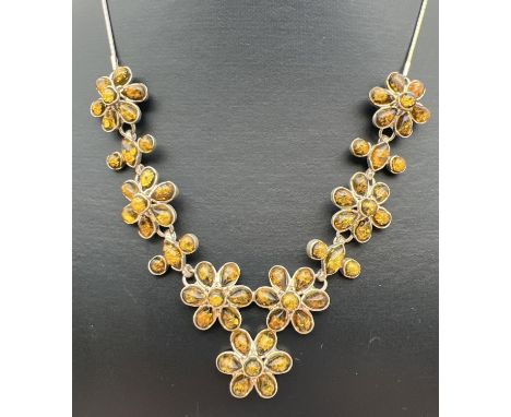A modern green amber set floral design fixed pendant necklace with spring ring clasp. Silver marks to both chain clasp and fi