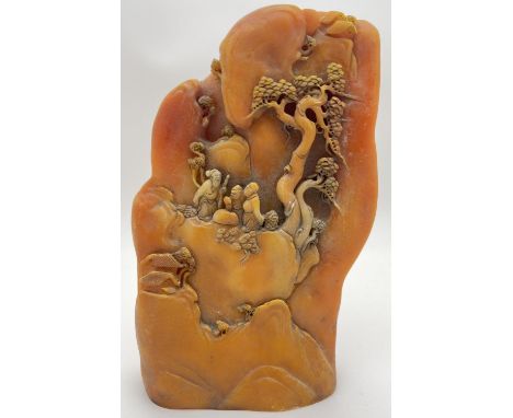 A large carved Chinese yellow/orange coloured boulder depicting figures, trees and houses on a mountainside. Approx. 22.5cm t