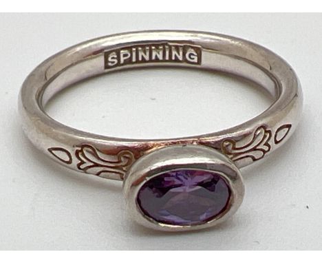 A Danish silver Spinning ring by Hans Henryk Nygaard. With bezel set oval cut amethyst and floral decoration to shoulders. Ri