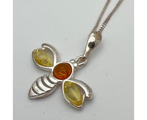 A small silver and amber pendant necklace modelled as a bumble bee and set with lemon &amp; cognac amber. On an 18" silver cu