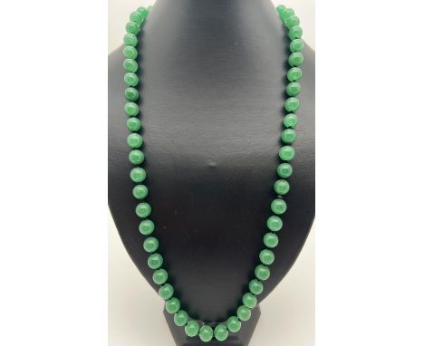 A 26" string of apple green jade beads, knotted between each bead. Beads approx. 1cm diameter. 
