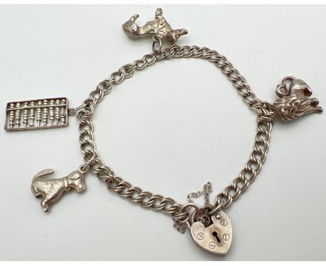 A vintage silver double curb chain charm bracelet with padlock and safety chain and 4 silver &amp; white metal charms. Charms