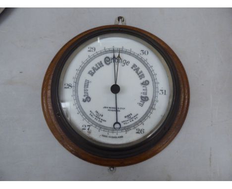 An early 20thC brass cased aneroid barometer, faced by a white enamel dial, inscribed John Barker &amp; Co Ltd Kensington, on