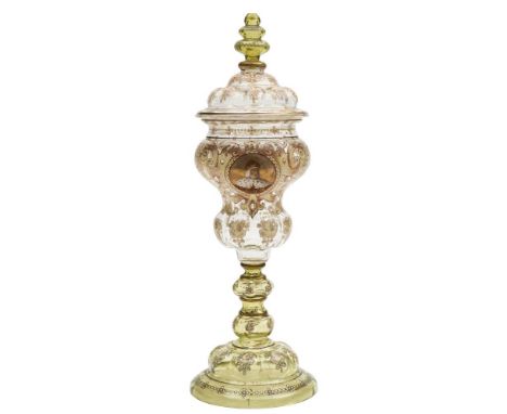 A large Bohemian glass cup and cover: in Moser style, the clear and green tinted glass enamelled with a portrait of a medieva