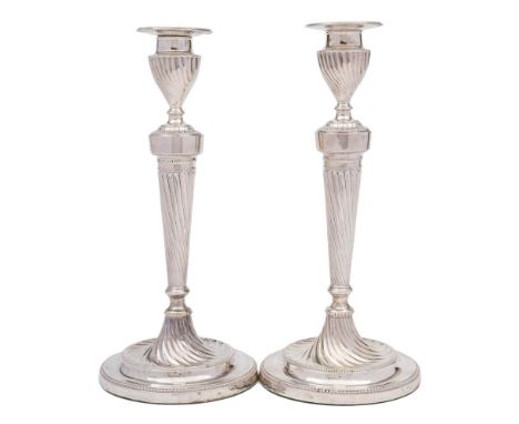 A pair of Victorian silver candlesticks, maker Hawksworth, Eyre &amp; Co Ltd, Sheffield, 1892: the urn-shaped nozzles with be