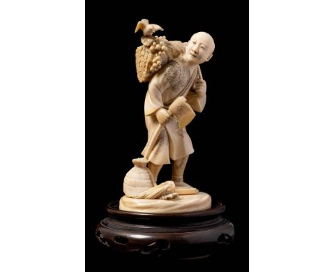 A Japanese carved ivory okimono of a woodcutter: the figure in traditional robes holding an axe in one hand and a bundle of w