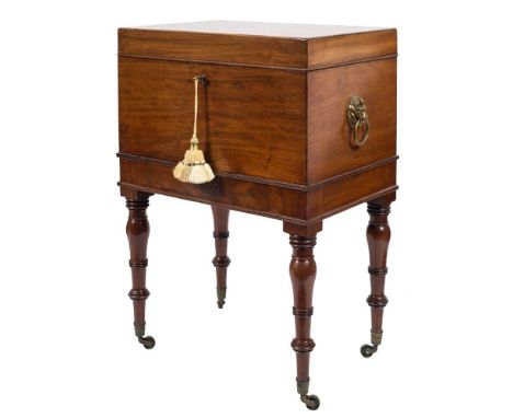 An early 19th Century mahogany rectangular cellarette:, the hinged top enclosing an interior with two divisions, having brass