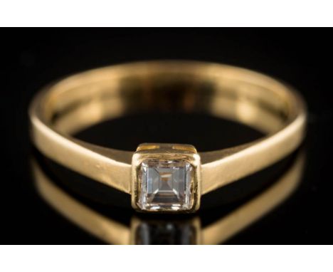 A square-cut diamond single-stone ring: the square-cut stone approximately 0.30ct in rub-over setting, the shank stamped '18c