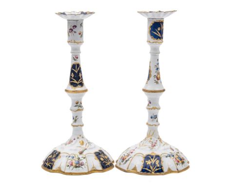 A pair of George III Bilston enamel candlesticks and sconces: each with knopped stem and domed foot, painted with floral spra