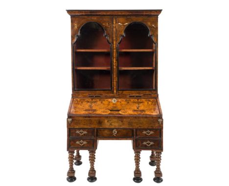 An early 18th Century Italian walnut and marquetry bureau bookcase:, the upper part with a cushion moulded cornice decorated 