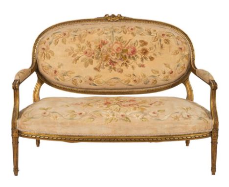 A carved giltwood canape in the Louis XVI transitional taste:, with rosebud, flowerhead and foliate cresting and beaded and f