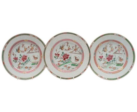 A set of three Chinese famille rose plates: each enamelled with a garden terrace scene with birds, prunus and peony within di
