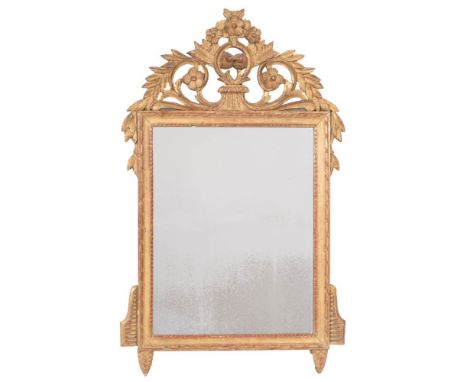 A carved giltwood mirror:, with pierced and shaped flowerhead, foliate scroll, arrow and laurel leaf cresting, the rectangula