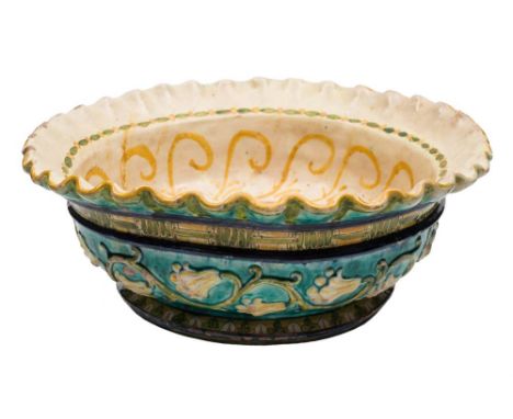 A large Della Robbia Pottery bowl by Lizzie Wilkins: with flared wavy rim, decorated to the interior with a sunburst and foli