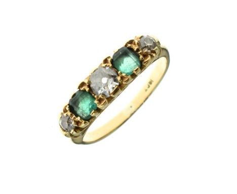 Dress ring set three graduated diamonds and two emerald coloured stones, the shank stamped 18ct,  size K½   Condition: 