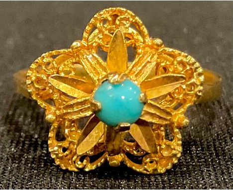 An 18ct gold star shaped filigree ring, set with a single polished turquoise stone, size O, marked 750, 4.4g 