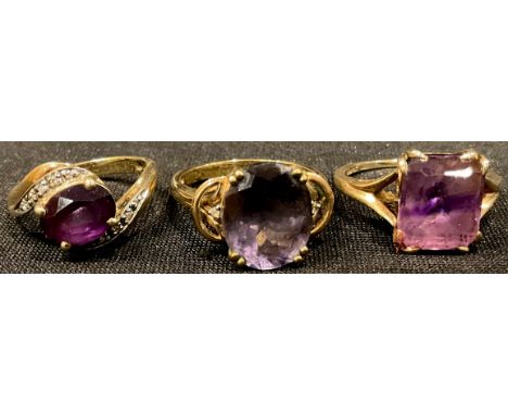 A 9ct gold ring, set with a central oval cut amethyst, size N/O; two other 9ct gold and amethyst dress rings, marked 375, 8.4