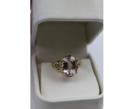 A Morganite set ladies dress ring, oval light pink facet cut stone set into a 10k band, with decorative shoulders, gross weig